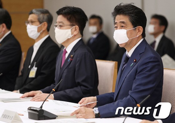아베 신조 일본 총리(오른쪽)가 지난 21일 오후 관저에서 코로나19 대책본부 회의를 주재하고 있다. © AFP=뉴스1