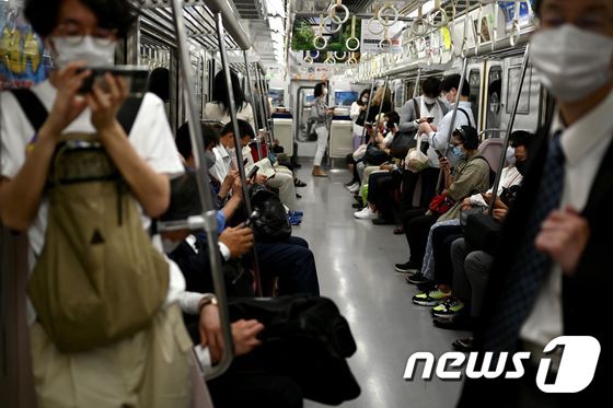 25일 일본 도쿄시내를 오가는 전철을 탄 승객들이 마스크를 착용하고 있다. © AFP=뉴스1