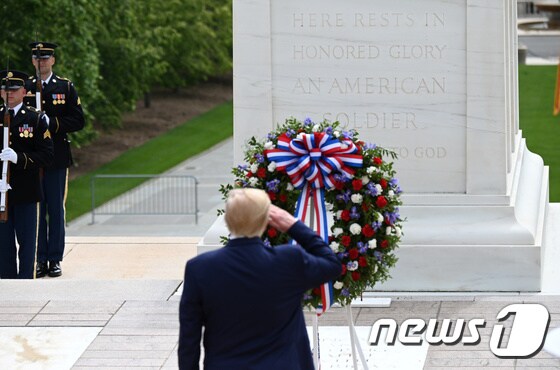 도널드 트럼프 미국 대통령이 25일 버지니아주 알링턴 국립묘지에서 무명용사 묘지에 헌화한 뒤 경례하고 있다. © 로이터=뉴스1