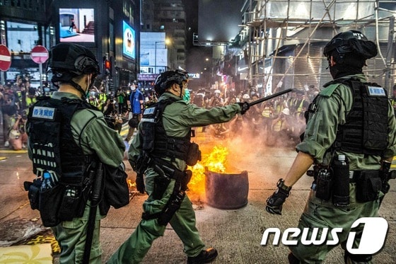 27일 홍콩 카우룽반도 몽콕에 설치된 바리케이드 앞에서 경찰과 시위대가 대치하고 있다.  © AFP=뉴스1