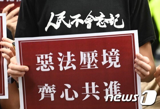 27일 홍콩에서 열린 국가보안법 반대 시위에서 학생 한 명이 '중국의 악법 국가 보안법' 이라고 적힌 플래카드를 들고 있다. © AFP=뉴스1