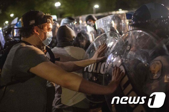 30일 새벽 워싱턴 DC의 백악관 밖에서 시위대가 경찰과 대치하고 있다.© AFP=뉴스1