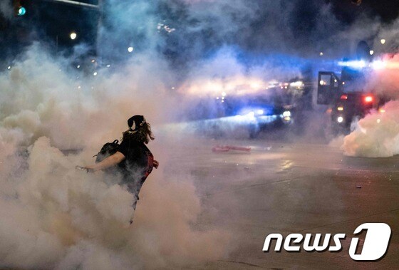 30일(현지시간) 미시간주 디트로이트에서 비무장 흑인 남성 조지 플로이드의 백인 경찰 가혹 행위로 숨진 사건에 항의하는 시위대가 경찰을 향해 최루탄을 되던지고 있다. © AFP=뉴스1 © News1 우동명 기자
