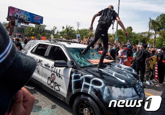 지난달 30일 캘리포니아주 로스앤젤레스에서 시위대가 경찰 차량을 파손하고 있다. © AFP=뉴스1 © News1 우동명 기자