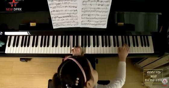 자신의 집에서 피아노를 치고 있는 평양에 사는 리수진 어린이. 유튜브 'New DPRK' 갈무리.© 뉴스1