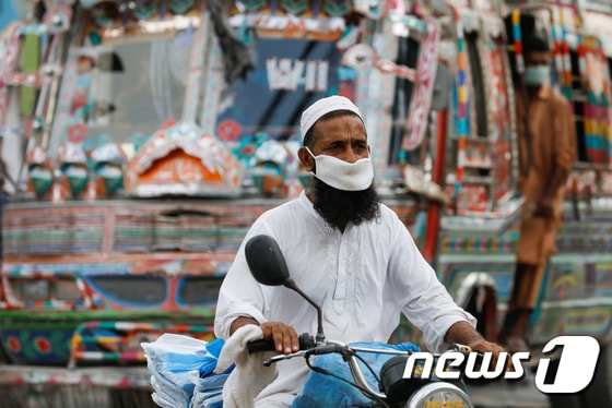 파키스탄 남부 카라치에서 한 남성이 마스크를 쓴 채 오토바이를 타고 있다. © 로이터=뉴스1