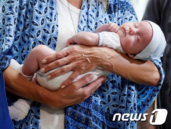 우크라이나 대리모를 통해 태어난 아기가 품에 안겨 있다. © 로이터=뉴스1
