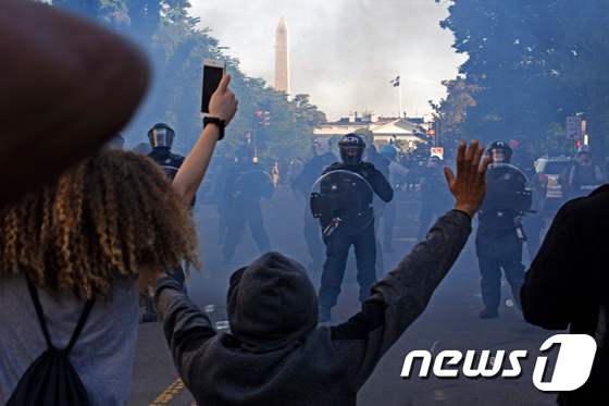  워싱턴 D.C.에서 폭동 진압 장비를 착용한 경찰들이 흑인 조지 플로이드의 죽음에 대한 항의시위대를 향해 최루탄을 발사하며 백악관 밖에서 밀어내고 있다. © AFP=뉴스1 © News1 이동원 기자