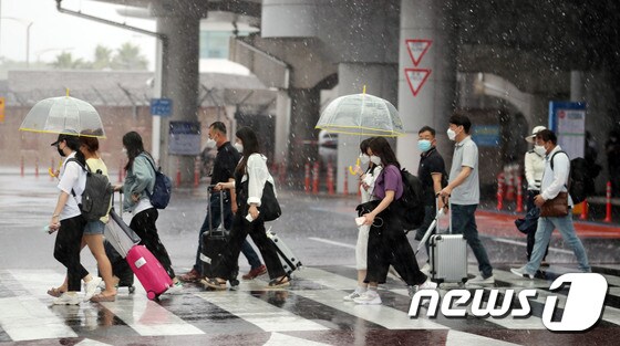 제주국제공항에서 관광객들이 비를 피해 발걸음을 옮기고 있다.2020.6.24/뉴스1 © News1 오현지 기자