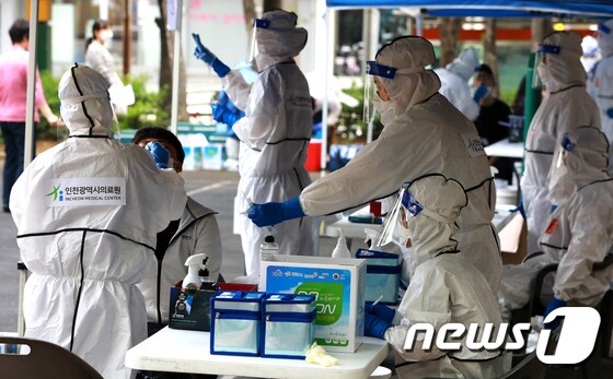  워킹스루 선별진료소에서 방역당국 관계자가 검사를 진행하고 있다. /뉴스1 © News1 정진욱 기자