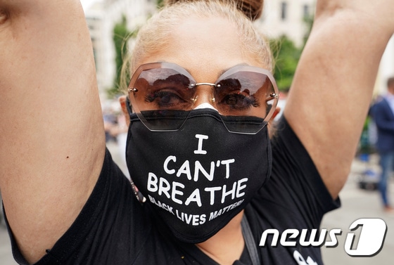 지난 2일 백악관 앞에서 한 여성이 'I can't breathe'란 문구가 새겨진 마스크를 쓰고 시위를 벌이고 있다. © 로이터=뉴스1 