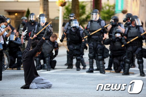 미국 조지아주 애틀랜타에서 한 시위자가 진압 경찰 앞에서 무릎을 꿇고 있다. <기사 내용은 사진과 무관> © 로이터=뉴스1