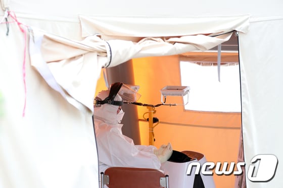7일 오후 서울 양천구 보건소 선별진료소에서 의료진이 더위를 식히고 있다. /뉴스1 © News1