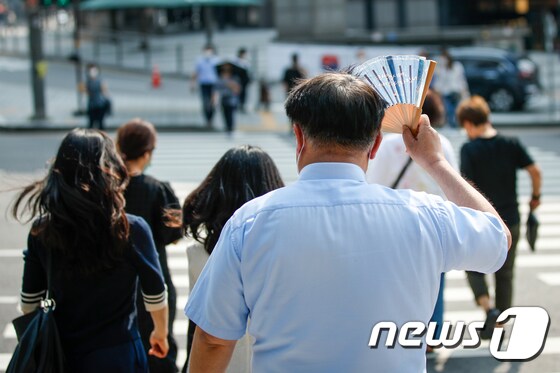 서울에 첫 폭염주의보가 발령된 8일 오후 서울 중구 회현사거리에서 한 시민이 부채로 햇빛을 가린 채 걸어가고 있다. 2020.6.8/뉴스1 © News1 안은나 기자