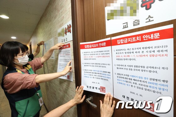 대전 동구에 위치한 교습소에서 구청직원들이 집합금지조치 안내문을 붙이고 있다. 7.1 © News1 김기태 기자