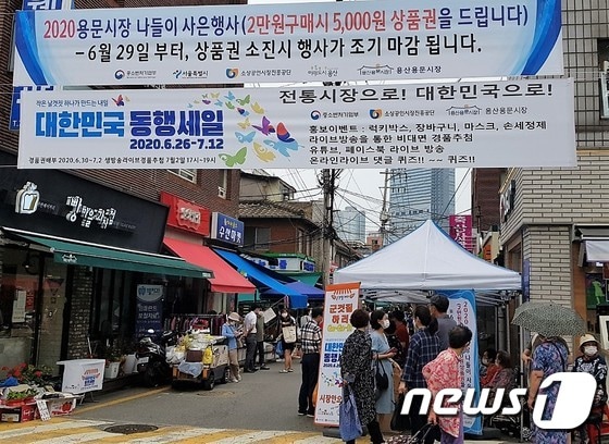 서울 용산구 용문시장 입구에 마련된 동행세일 이벤트 코너에 사람들이 몰려있다. © 뉴스1 조현기 기자