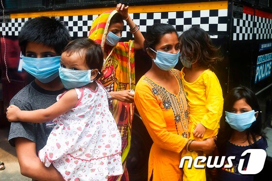 28일(현지시간) 인도 콜카타에서 마스크를 쓴 가족이 신종 코로나바이러스 감염증(코로나19) 검사를 받기 위해 기다리고 있다.  © AFP=뉴스1