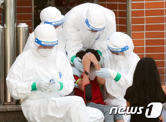서울 중랑구의 한 초등학교에 마련된 선별진료소에서 지난 5일 의료진들이 진단검사를 받는 학생을 위로하고 있다./뉴스1 © News1 허경 기자