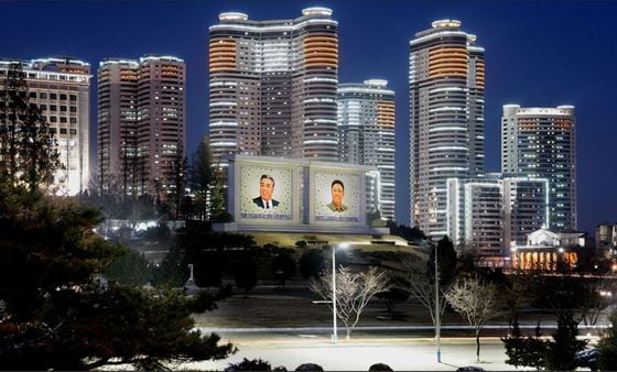 북한 대외 선전매체 '류경'이 공개한 평양의 야경. 김일성 주석과 김정일 국방위원장의 사진이 도로 한 가운데 전시돼 조명을 받고 있다.(류경 갈무리)© 뉴스1