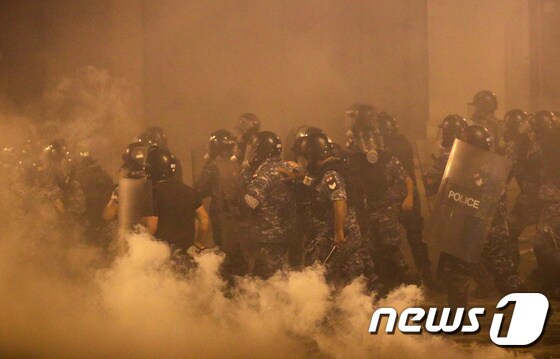 9일(현지시간) 최루탄 연기가 자욱한 가운데 레바논 경찰들이 시위를 진압하고 있다. © 로이터=뉴스1
