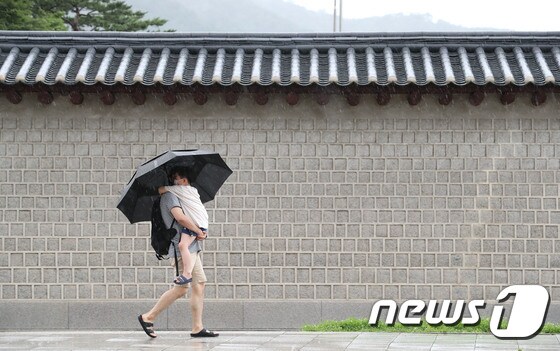 서울 종로구 세종대로 인근에서 한 시민이 우산을 쓴채 아이를 안고 발걸음을 재촉하고 있다. 2020.8.2/뉴스1 © News1 임세영 기자