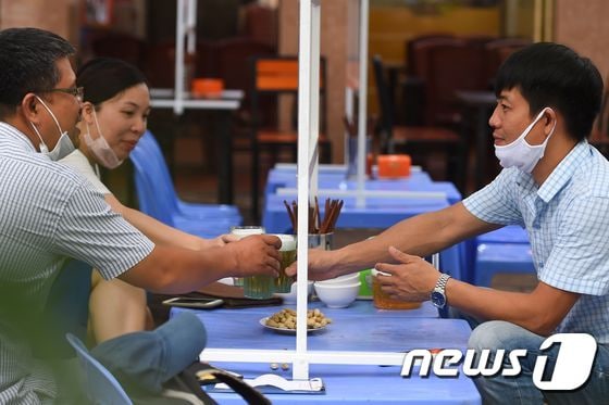 베트남 하노이 한 상점 테이블 위에 신종 코로나바이러스 감염증(코로나19) 확산을 막기 위한 플라스틱 가림막이 설치돼 있다. © AFP=뉴스1