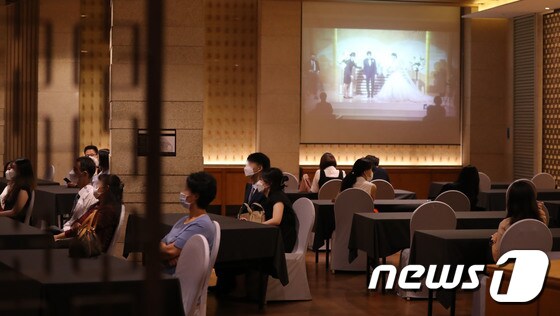 8월 23일 서울 시내의 한 대형 웨딩업체 웨딩홀에서 하객들이 온라인 화면으로 결혼식을 지켜보고 있다. 2020.8.23/뉴스1 © News1 임세영 기자