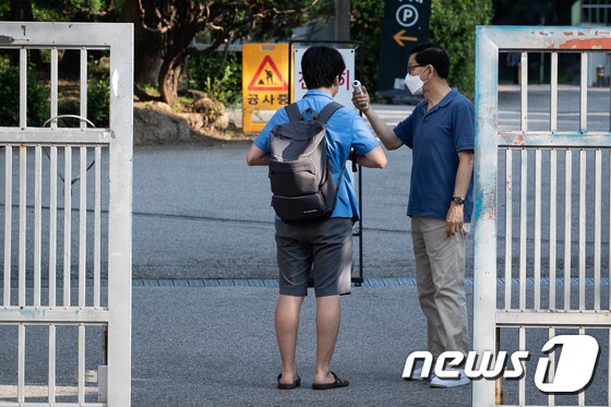 수도권 지역 전면 원격수업이 시행된 지난 26일 서울시내 한 고등학교에서 한 고3 학생이 등교하며 발열체크를 받고 있다. 6/뉴스1 © News1 유승관 기자
