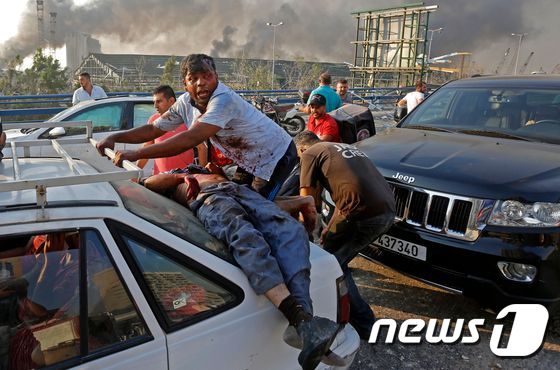 4일(현지시간) 레바논 베이루트항 선착장에 있는 창고에서 대규모 폭발사고로 부상을 당한 시민이 차량에 기대어 누워 있다. © AFP=뉴스1 © News1 우동명 기자