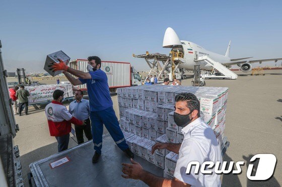 이란 적신월사 직원들이 5일(현지시간) 테헤란에 있는 한 공항에서 레바논에 보낼 지원용품을 비행기에 싣고 있다.© AFP=뉴스1