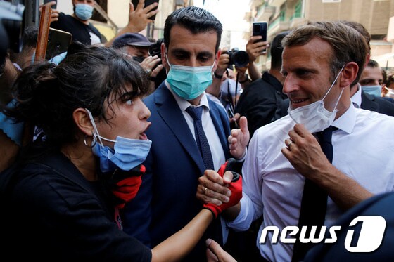 베이루트의 한 시민이 마크롱 프랑스 대통령의 손을 잡고 호소하고 있다. © 로이터=뉴스1