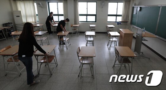 오는 21일부터 수도권 소재 유치원과 초·중·고등학교도 등교수업을 재개하는 가운데 지난 15일 서울 동작구 소재 한 고등학교에서 교사들이 책상을 배치하고 있다./뉴스1 © News1