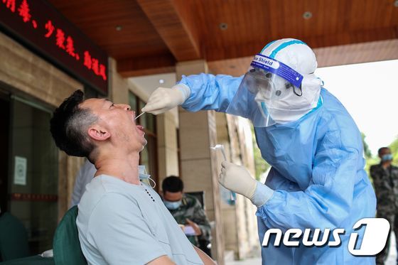 15일 중국 남서부 윈난성 루이리시 주민들이 코로나19 진단검사를 받고 있다. © AFP=뉴스1