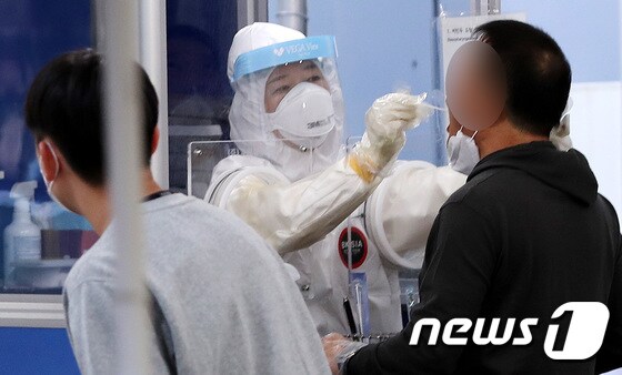 서울 송파구 선별진료소에서 한 시민이 신종 코로나바이러스 감염증(코로나19) 검체 검사를 받고 있다./뉴스1 © News1 박지혜 기자