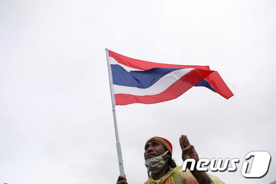 19일 태국 방콕에서 한 남성이 깃발을 들고 시위에 참석하고 있다. © 로이터=뉴스1