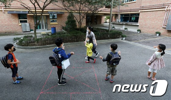 지난달 21일 경기 군포시 소재 한 초등학교에서 유치원생들이 등원하며 서로 인사를 나누고 있다./뉴스1 © News1