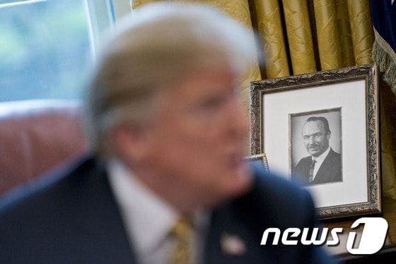 도널드 트럼프 미국 대통령 백악관 집무실 뒤로 부친 프레드 트럼프 시니어의 사진이 놓여 있다. (뉴욕타임스) © 뉴스1