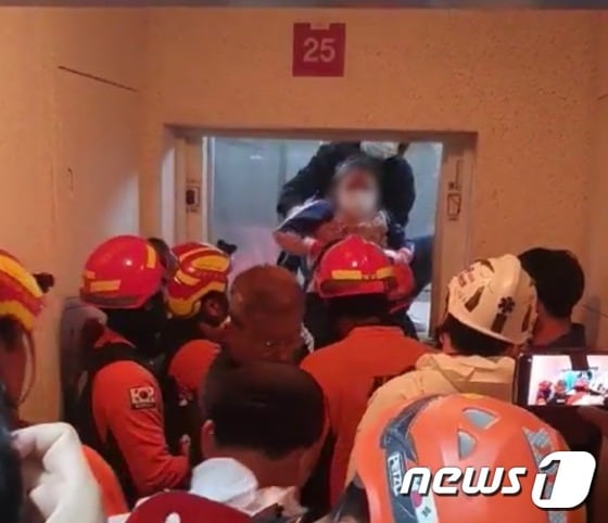 엘리베이터에 2시간 넘게 갇혀 있다가 구조되고 있는 모녀 모습.(부산경찰청 제공) /© 뉴스1