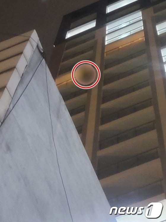 A씨가 14층 발코니에 매달려 있는 모습.(부산경찰청 제공)© 뉴스1