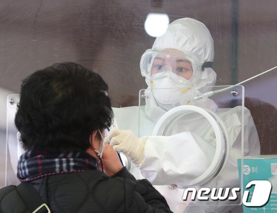  13일 서울역 광장에 마련된 임시선별진료소에서 의료진이 검체 채취를 하고 있다. 2021.1.13/뉴스1 © News1 이성철 기자