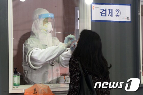 15일 오전 서울역 광장에 마련된 신종 코로나바이러스 감염증(코로나19) 임시선별진료소에서 시민이 검사를 받고 있다.2021.1.15/뉴스1 © News1 황기선 기자