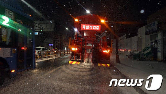 전국 곳곳에 대설 특보가 발효중인 17일 저녁 눈이 내린 서울 동작구 장승배기역 인근 상도로에서 제설 차량이 도로에 염화칼슘을 뿌리며 이동하고 있다. (동작구청 제공) 2021.1.17/뉴스1