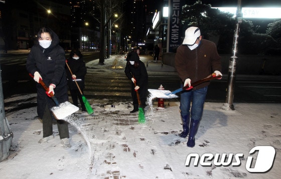 제설대책 비상근무에 나선 동작구청 직원들이 17일 저녁 눈이 내린 서울시 상도동 도로에서 서 주민들의 안전을 위해 염화칼슘을 뿌리며 제설작업을 하고 있다. (동작구청 제공) 2021.1.17/뉴스1