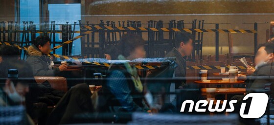 포장·배달만 가능했던 카페에서 매장 내 취식이 가능해진 18일 서울시내 카페를 찾은 시민들이 테이블에 앉아있다. 2021.1.18/뉴스1 © News1 안은나 기자