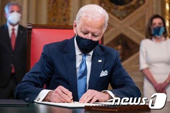 조 바이든 미국 대통령이 20일(현지시간) 워싱턴 백악관에서 취임 후 첫 업무로 파리 기후변화 협약 복귀 등 3건의 행정명령에 서명을 하고 있다. © AFP=뉴스1 © News1 우동명 기자