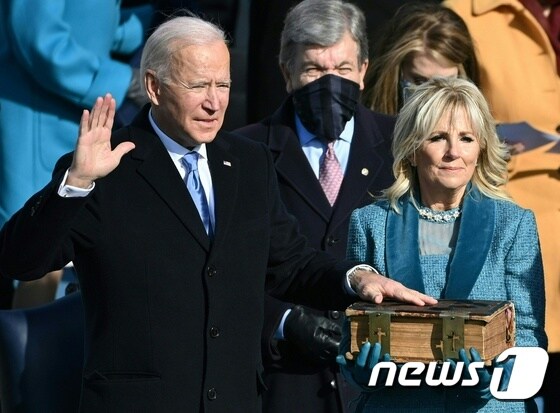 조 바이든 미국 대통령이 20일(현지시간) 워싱턴 의사당에서 부인 질 바이든 여사가 들고 있는 성경에 손을 얹고 존 로버츠 대법원장이 지켜보는 가운데 취임선서를 하고 있다. © AFP=뉴스1 © News1 우동명 기자