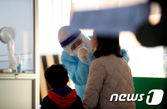 24일 오후 광주 북구선별진료소에서 엄마와 자녀가 함께 코로나19 검사를 받고 있다. 2021.1.24/뉴스1 © News1 DB