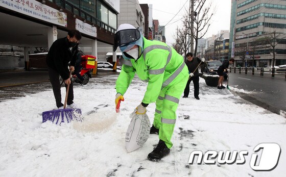 28일 오전 제설대책 비상근무에 나선 동작구청 직원들과 인근 상가 주민들이 서울 동작구 상도동 인근 도로에서 염화칼슘을 뿌리며 제설작업을 하고 있다.(동작구 제공)2021.1.28/뉴스1