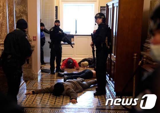 6일(현지시간) 워싱턴 의사당에 난입한 도널드 트럼프 미국 대통령 지지자들을 경찰이 체포를 하고 있다. © AFP=뉴스1 © News1 우동명 기자