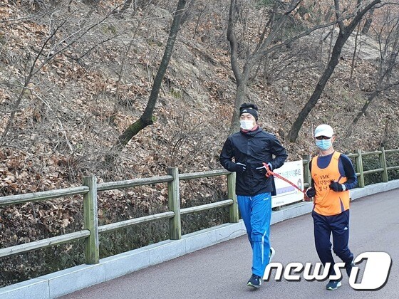 전맹(全盲) 장애인 마라토너 정운로씨(50)와 그를 돕는 동반주자 조성수씨(30)가 남산을 달리고 있다. © 뉴스1/정혜민 기자
